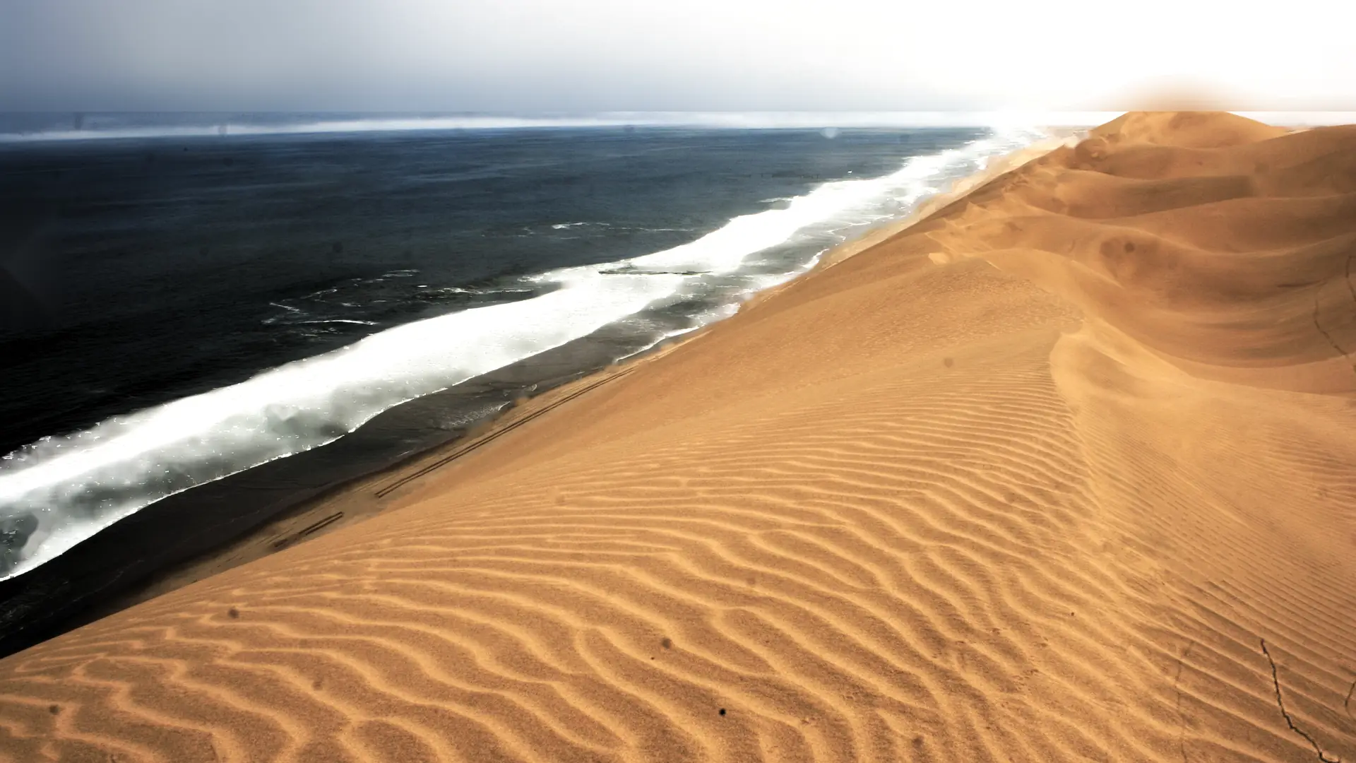 Die duine van die Namib wat reguit in die Atlantiese branding by Sandwich Harbour loop