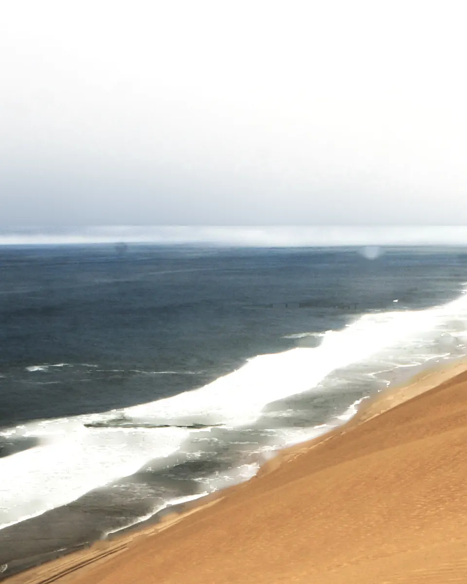 Die Dünen des Namib laufen am Sandwich Harbour direkt in die Brandung des Atlantiks